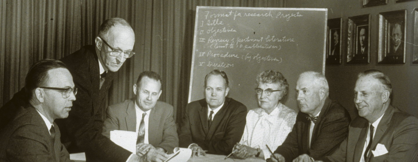 Historic photo of Morris Animal Foundation’s early Scientific Advisory Board, including founder Mark L. Morris Sr., reviewing animal health research proposals, highlighting Morris Animal Foundation’s long-standing commitment to rigorous scientific funding.