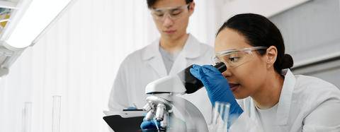 person looking at microscope